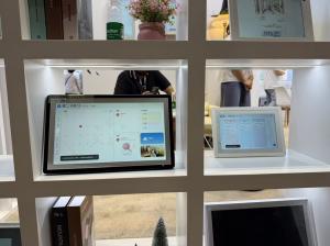 Home displays on exhibition shelves showing family calendar and planning interfaces.
