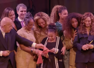 A group shot of individuals celebrating a ribbon cutting.