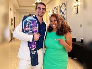 Dr. Cole Herzik holding the Dentistry's Got Talent championship belt next to runner-up Dr. Catrise Austin in Miami