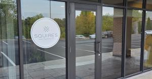 Exterior entrance of Squires Tax Planning’s new Osage Beach office, featuring the firm’s logo on the glass storefront and Suite 101 signage above the door.