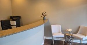 Reception area inside Squires Tax Planning’s new Osage Beach office, featuring a curved front desk, visitor seating, wood-look flooring and a welcoming, modern interior.