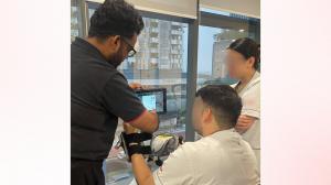 Participant trying RevitaVivante ProMax upper limb setup with Robotimize team