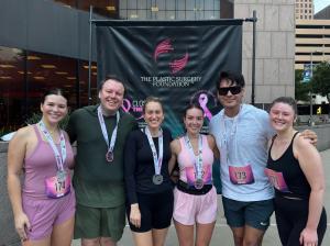 Six Vitenas Cosmetic Surgery team members wearing finisher medals pose together in front of The Plastic Surgery Foundation banner after Houston’s Close the Loop 5K on October 16, 2026.