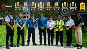 Nine Citiguard security officers and staff in various uniforms stand in a row on an outdoor walkway in front of an office building, with the Citiguard logo and nine Top Workplaces October 2026 award badges displayed above them.