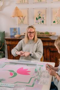 Heather Cannon smiling at a mahjong table with a pink tulip mat