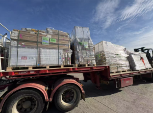 Palletized and wrapped furniture packages loaded on a flatbed truck at a consolidation warehouse in Foshan