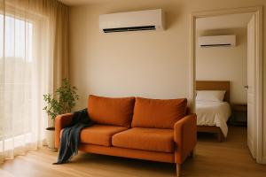 Apartment lounge and bedroom in Johannesburg, each cooled by its own white wall-mounted aircon indoor unit running from a single multi-split system