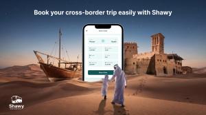 Shawy app on a smartphone showing a Muscat to Riyadh bus booking screen, set in a desert at night with a traditional dhow, a wind-tower fort, and a father and son walking, with text "Book your cross-border trip easily with Shawy"