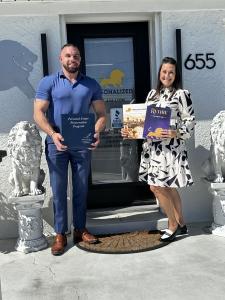 Aaron Wright and Jeanne Hedrick outside Personalized Retirement Planners in Cookeville, Tennessee, displaying estate planning materials and the book Retire the Wright Way.