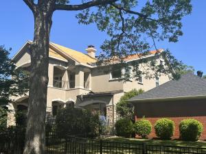 Roofer installing new roof decking on a two-story stucco home during a roof replacement in Cabot, Arkansas