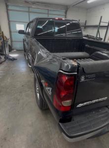 Crumpled rear bed side and corner of a black Chevrolet Silverado pickup before collision repair in Cabot, Arkansas