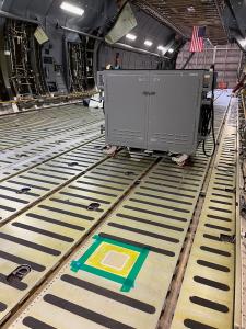 Corrdesa's Volta mobile anodizing equipment positioned inside a C-5 Galaxy cargo bay at Westover Air Reserve Base, beside a taped-off repair area on the aircraft's cargo floor.