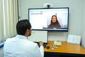 KFSH physician speaking with a patient on a video call screen