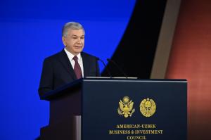 The image captures the President of Uzbekistan delivering a speech at the opening of the second meeting of the U.S.–Uzbekistan Business and Investment Council, held in Samarkand.