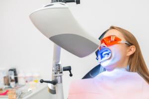 Woman undergoing professional teeth whitening treatment at a dental clinic