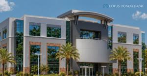 Exterior of a modern multi-story building with glass windows and palm trees, featuring the Lotus Donor Bank logo.