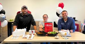 Three BHMG Engineers team members gather around a table with a welcome lunch at the company’s new Bettendorf, Iowa, office.