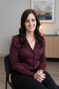 Courtney Bierman, founder and president of Bierman Autism Centers, smiling while seated in an office, wearing a burgundy blouse.
