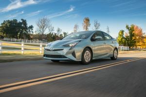 Green 4th generation Toyota Prius at speed