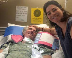 Erica Bazerkanian with her father, Jeff Stone, during the five months after his 2016 spinal cord stroke. Around him are cards from his grandchildren and first-place ribbons his grandson gave him.