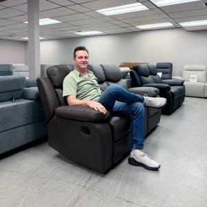 Sergei Tashlikowich Sitting on Aveon 83 Inch Pillow Top Arm Reclining Sofa in Leather Match
