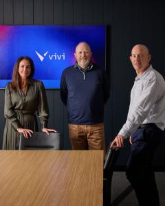 Photo of 3 individuals who lead Vivi standing in a board room in front of a Vivi sign. The individuals are pictured are Natalie Mactier, Vivi’s Global CEO, Jim Holm, CEO, Vivi North America, and Dr. Lior Rauchberger, Founder of Vivi.