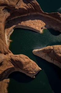 Winding river up close in arial view of green winding river between smooth canyon walls
