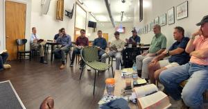 Men seated in a circle with books and coffee at a Chattanooga men's book club meeting