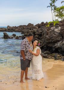 Couple smiles along the Hawaii shoreline during their Big Island wedding renewal with Kona Wedding Officiant®.