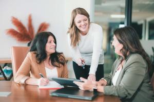 Three members of the PDS Planning team consult around a conference table.