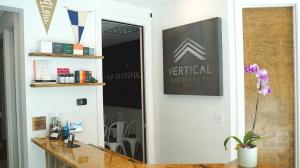 image showing the interior of the vertical chiropractic office in sarasota to include signage on the wall and a desk space where clients can sign in and talk with staff