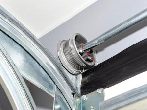 Residential garage door lifting cable and track hardware inspected for repair.