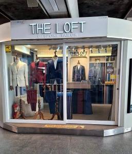 The Loft Bespoke Tailor shopfront with mannequins in suits, inside BTS National Stadium Station
