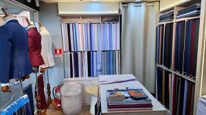 Interior of The Loft Bespoke Tailor with shelves of cloth and mannequins in suits