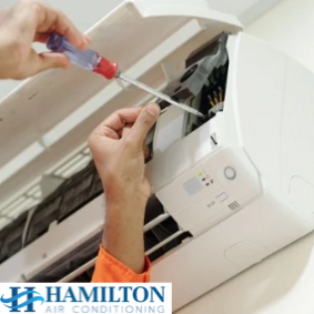 Technician carrying out maintenance on an air conditioning unit