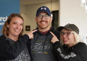 A man with dental implants smiling with two friends.