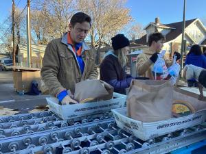 Denver Mayor Mike Johnston joins volunteers on the food distribution line