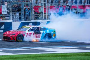 Chase Briscoe’s red, white and blue No. 19 Free Bird Toyota surrounded by tire smoke during a celebratory burnout at Charlotte Motor Speedway.