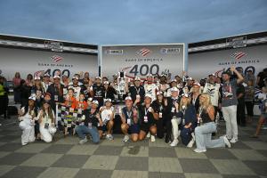 Chase Briscoe, the Joe Gibbs Racing team and Free Bird representatives gather around the Bank of America 400 trophy in Victory Lane.
