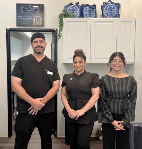 Dr. Ryan Watkins and two team members standing together in the office at Dreamtime Dentistry