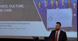 IMA Founder and Managing Director at a podium in front of the Ethics, Culture, and Care workshop slide at UC Davis