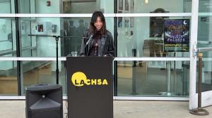 Emery, a senior student artist in LACHSA’s Design and Production program stands at a podium speaking at the John C. Hench Lab ribbon cutting ceremony.