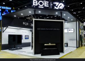 BOE stand with an illuminated 30th-anniversary sign, dark overhead canopy, large central screen and wall-mounted displays.