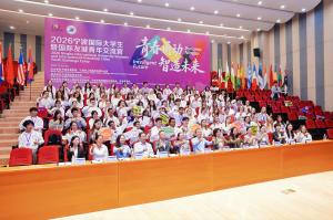 Young people and officials seated in an auditorium at the opening of a Ningbo youth exchange camp