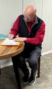Enrolled Agent John Wisener signing a document at McMullen Tax Service