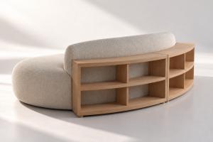 A curved, custom bookcase follows the silhouette of the Nathan Anthony Furniture Anders sofa.