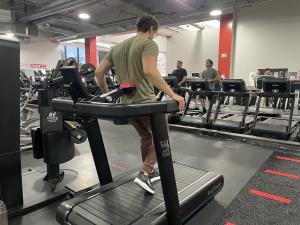 Person walking backward on the BodyEnergy treadmill with adjustable magnetic resistance engaged for added intensity.