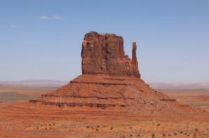 Red rock butte standing alone in desert landscape