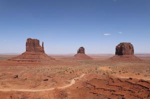 Three red buttes standing in a triad formation among the vast desert landscape