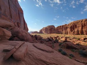Smooth red rock below feet in photo with massive red mesa on eye level view in distance